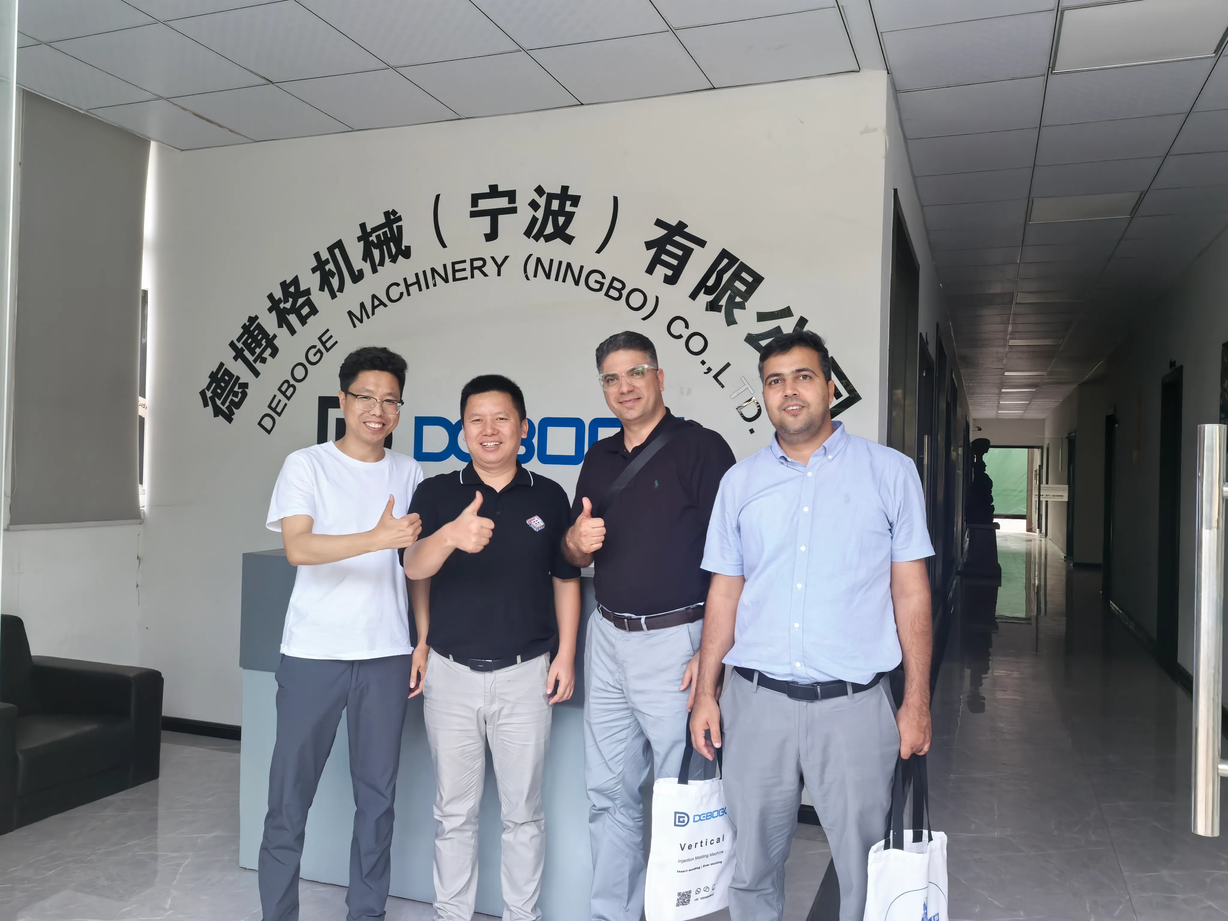 International customers touring vertical injection molding machine workshop with Deboge team