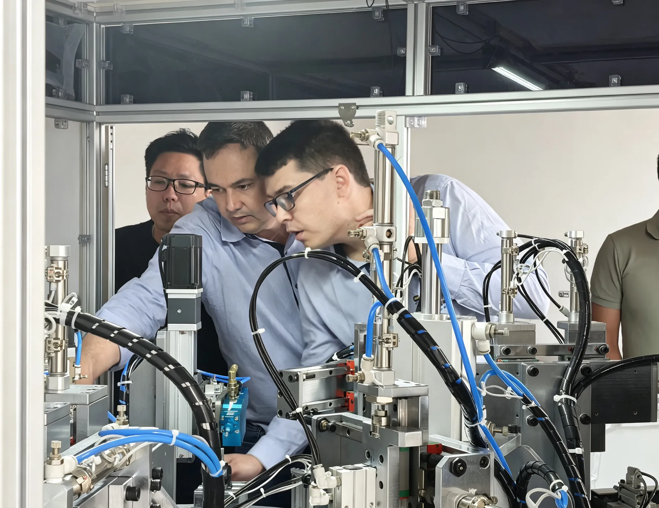 Customer and Deboge engineer inspecting a vertical injection molding machine during factory visit