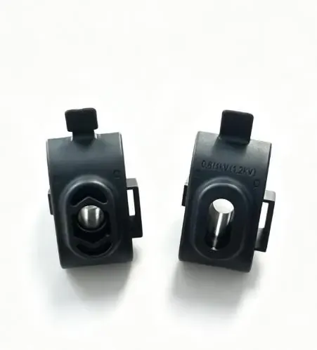Two separate black molded insulation piercing connector components with visible metal features